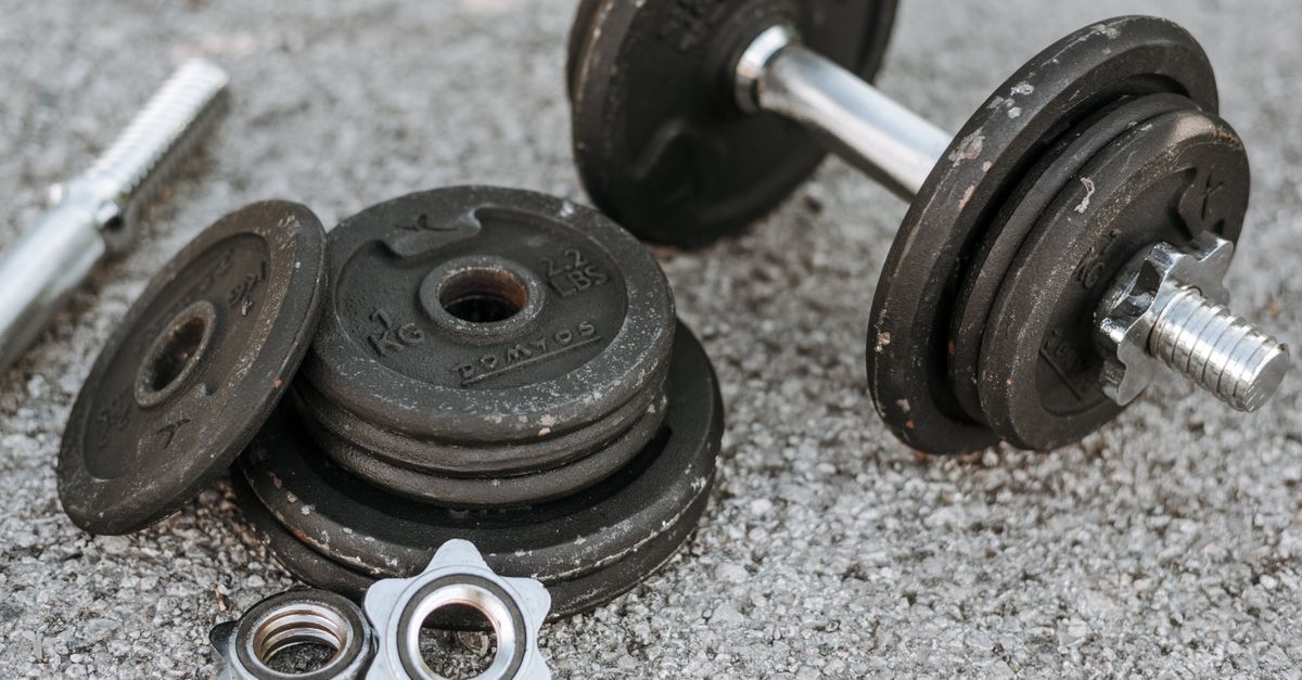 Weathered heavy adjustable dumbbell with details for regulating weight for muscle training on paved ground
